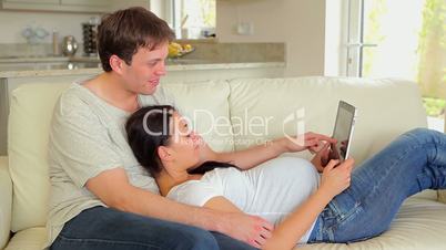Expecting couple viewing pictures on the tablet pc