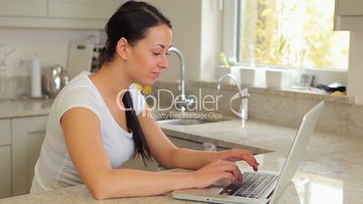 Woman typing on the laptop and smiling