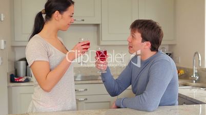 Couple drinking red wine with husband presenting gift