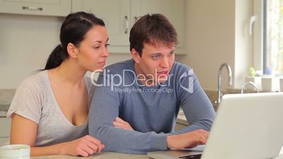 Couple talking and looking at laptop