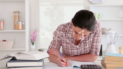 Woman studying with books and calculator