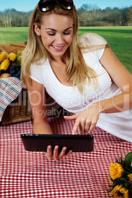 Woman using a tablet on a picnic