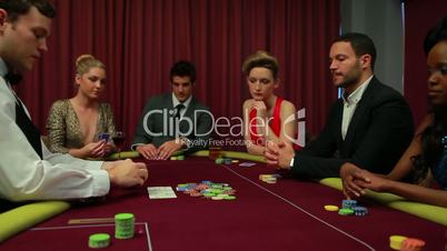 Dealer dealing poker cards and bets are being placed