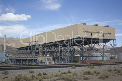 Power plant factory next to train track in the desert