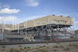 Power plant factory next to train track in the desert