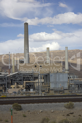 Power plant factory next to train track in the desert