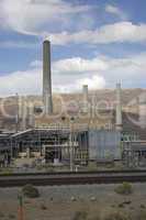 Power plant factory next to train track in the desert