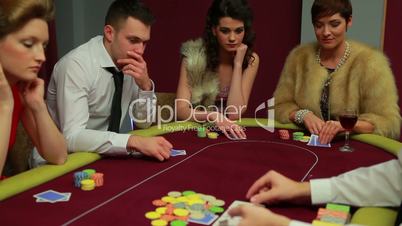 Four people playing poker and one is folding