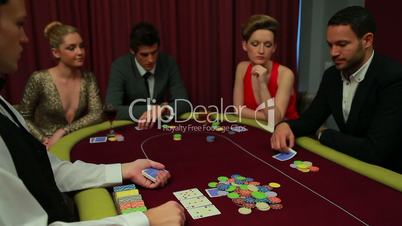 Four people playing poker and one going all in