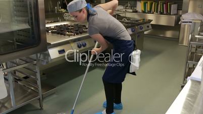 Cleaner of a kitchen wiping the floor