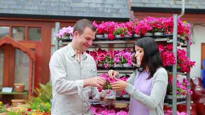 People standing in front of a flower shelf