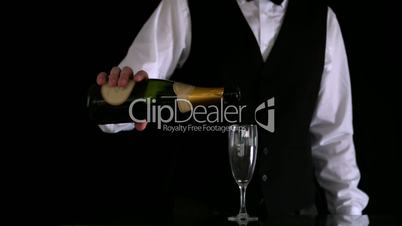 Waiter topping up champagne flute