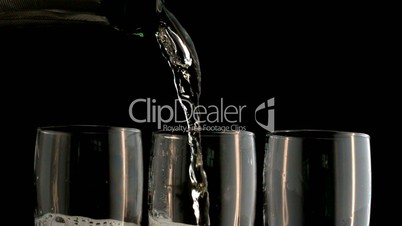 Three champagne flutes being filled