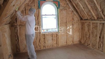 Builder in protecive suit insulating house