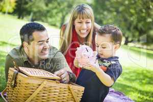 Mixed Race Couple Give Their Son a Piggy Bank at the Park
