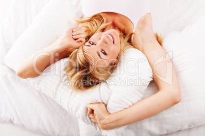 Lazy woman stretching in bed