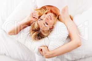 Lazy woman stretching in bed