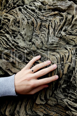 Frauen-Hand mit Ring auf zerklüftetem Stein