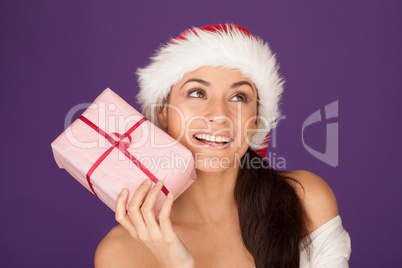 Beautiful brunette in Santa hat with gift