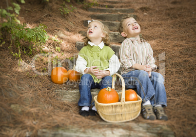 Brother and Sister Children on Wood Steps with Pumpkins Singing