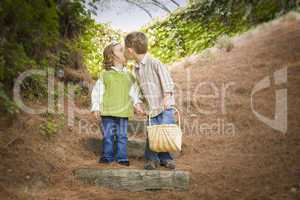 Two Children with Basket Kissing Outside on Steps