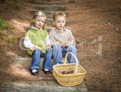 Two Children on Wood Steps with Basket of Pine Cones