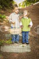 Two Children with Basket Collecting Pine Cones Outside
