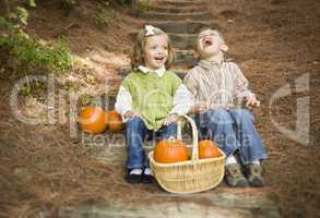 Brother and Sister Children Sitting on Wood Steps with Pumpkins