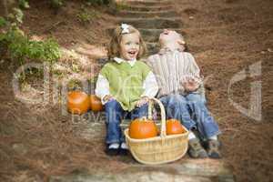Brother and Sister Children Sitting on Wood Steps with Pumpkins