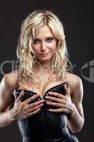 Sexy blond woman in leather corset take breast