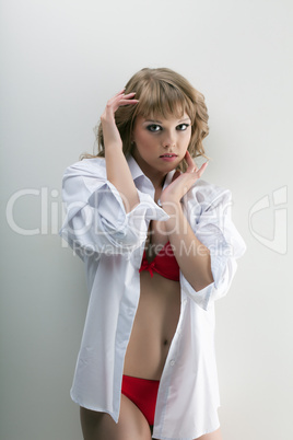 young woman in red bra posing near white wall