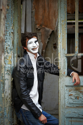 Guy mime against the old wooden door.