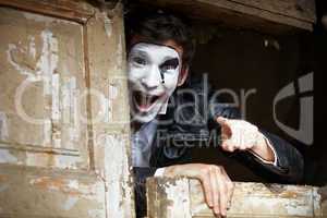 Guy mime against the old wooden door.