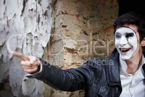 Guy mime against an old brick wall.