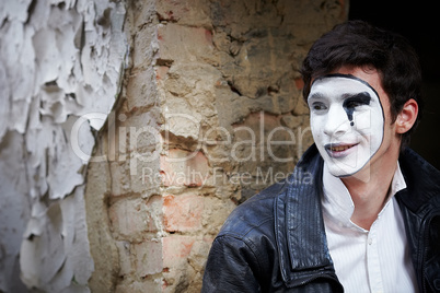 Guy mime against an old brick wall.