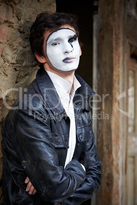 Guy mime against an old brick wall.