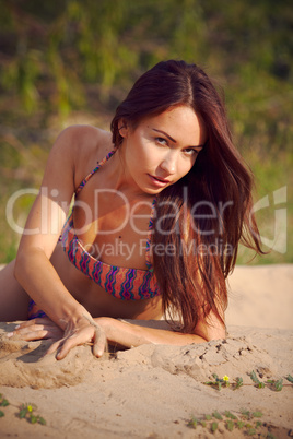 Cute  girl in a bikini on a background a pine-wood.