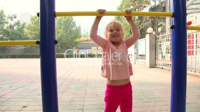 Happy little girl climbing in playground