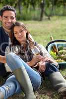 Couple with a glass of wine and basket of grapes