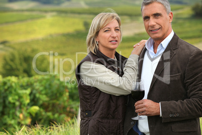 Couple drinking a glass of wine in a vineyard