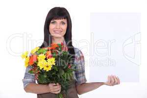Florist with a bunch of flowers and a board left blank for your message