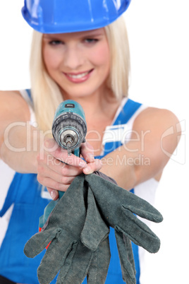 Tradeswoman aiming a screwdriver