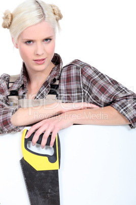 young handywoman posing with saw