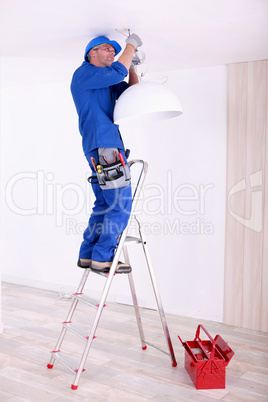 Electrician hanging a ceiling light