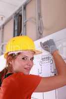 A female electrician installing a wire board.