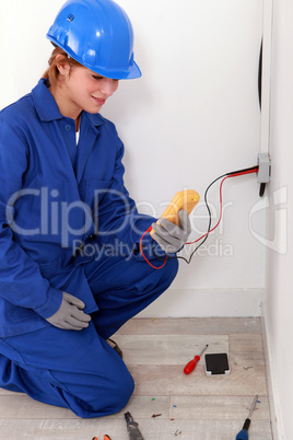 Female electrician taking electrical reading