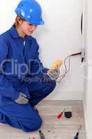 Female electrician taking electrical reading