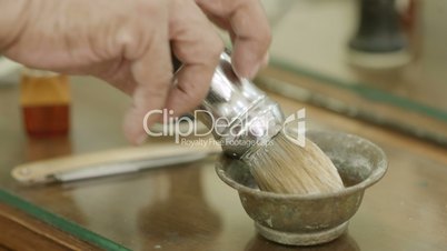 Close-up of man at work as barber preparing shaving cream