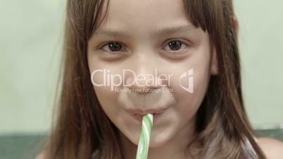 Portrait of pretty female child with lollipop smiling