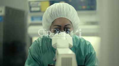 Woman at work with microscope in biotechnology laboratory